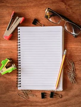 Top view from blank notepad workspace with pencil, glasses, paperclip Stock Photos