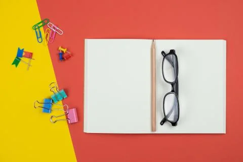 Top view of blank open notebook with pencil and stationery items and eyeglass Stock Photos
