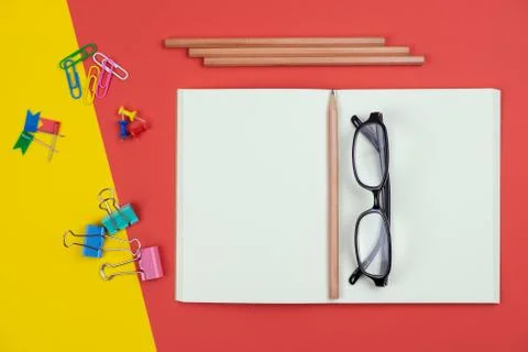 Top view of blank open notebook with pencil and stationery items and eyeglass Stock Photos