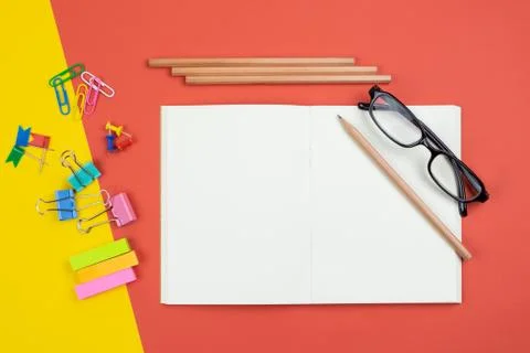 Top view of blank open notebook with pencil and stationery items and eyeglass Stock Photos