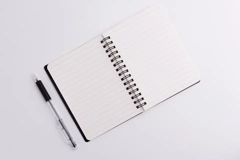 Top view of blank open spiral notebook and black pen isolated on white back.. Stock Photos