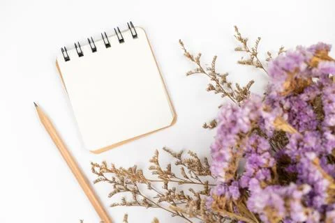 Top view of a blank paper note with pencil and flower bouquet Stock Photos