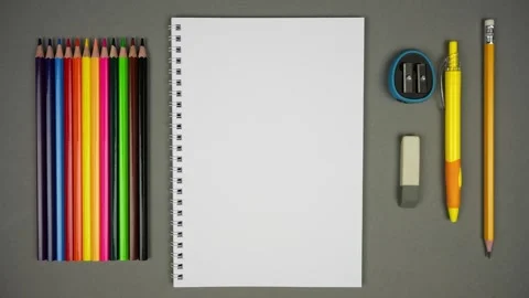 Top view of Blank Spiral Notebook With Color Pencils On Grey Background Stock Footage 244041753