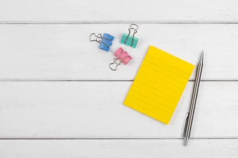 Top view of a blank sticky note with pencil and paper clips Stock Photos