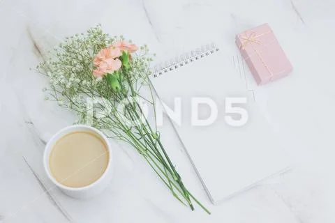 Top view blank white notebook,coffee cup,gift box and boquet of carnation an Stock Photos