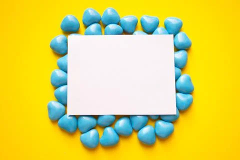 Top view on a blue dragee in the shape of hearts. A card for text. Yellow Stock Photos