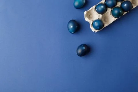 Top view of blue painted easter eggs and egg tray on blue surface 库存照片