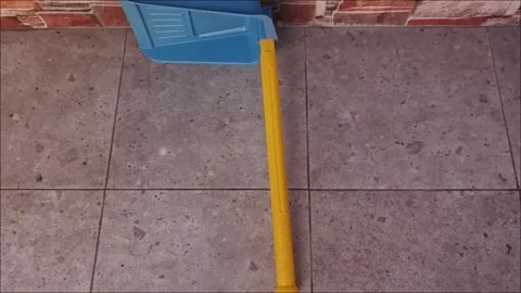 Top View of Blue Plastic Dustpan with Yellow Long Handle on Floor Video stock 331913876
