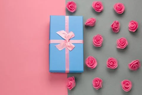 Top view blue present box with pink bow and delicate pink roses pattern on a  Stock Photos