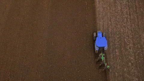 Top view of a blue tractor plowing a field, ground furrow Stock Footage 127628696