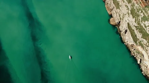 Top view of a boat making its way across the lake between the canyons. Stock Footage 237276599