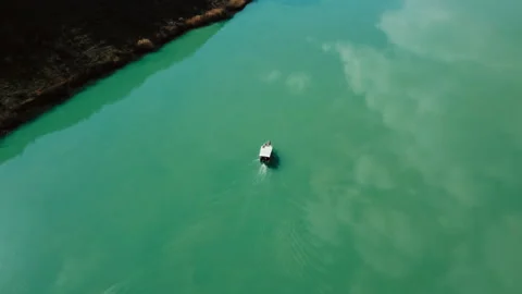 Top view of a boat sailing on the river. Reflection of sky on the river. Stock Footage 237653307