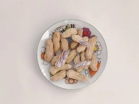 Top view of Boiled peanuts served on a plate on a white background. Stock Photos