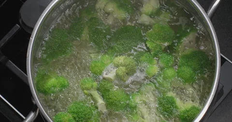 Top view of boiling broccoli in a pot. Male hand throws broccoli in boiling Stock-Footage 251939173