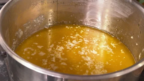 Top view of boiling butter in a pot on the stove top Video stock 301900123