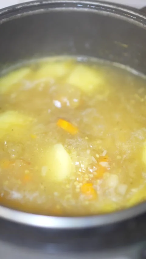 Top view of boiling potato soup with carrots inside multicooker. Stock Footage 345740950