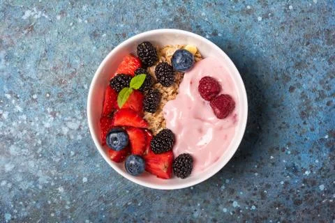 Top view of bowl with oat flakes, raspberry, strawberry, blueberry and fruit  Stock Photos