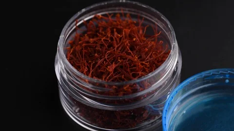 Top view box high quality red saffron threads. Slowly rotating on black. 動画素材 128676116