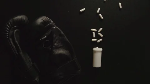 TOP VIEW: Box of pills falls on the table next to boxing gloves Stock Footage 108417290