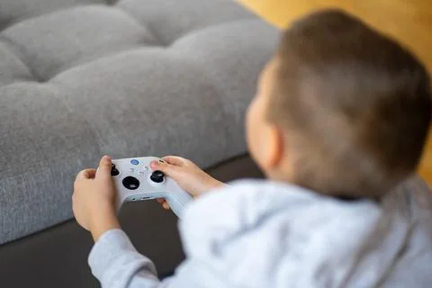 Top view of a boy in a gray hoodie playing on a game console Stock Photos
