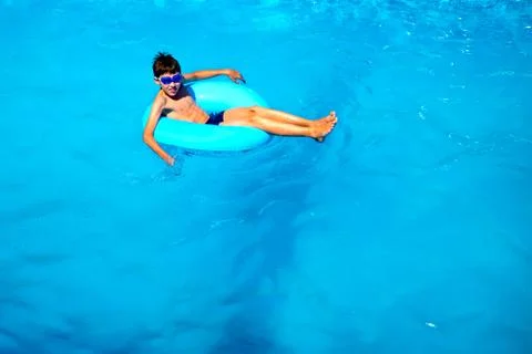 Top view boy in the pool on an rubber ring, healthy lifestyle concept. Stock Photos