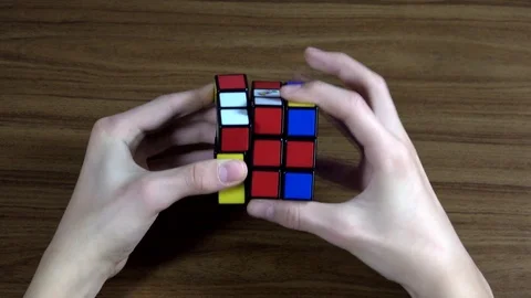 Top view of boys hands solving Rubik's Cube originally called Magic Cube . Stock Footage 124079273