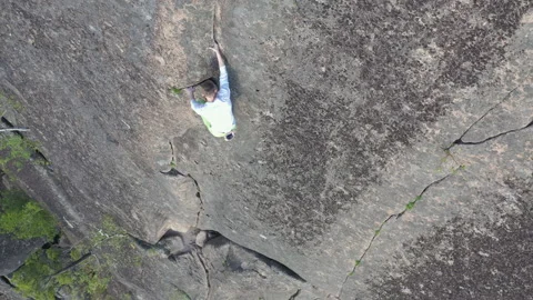 Top view of a brave man climbing without insurance to the top of a mountain on a Stock Footage 130897587