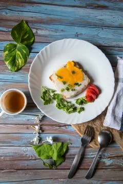 Top view of bread and poached egg on a plate with a cup of tea Stock Photos