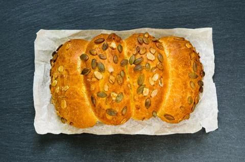 Top view of bread loaf with pumpkin seeds on black slate stone board Foto stock