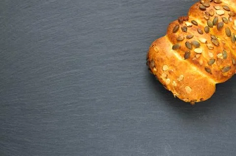 Top view of bread loaf with pumpkin seeds on black slate stone board Stock Photos