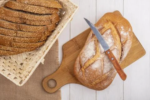 Top view of breads as brown sliced seeded cob in basket on sackcloth and cr.. Stock Photos