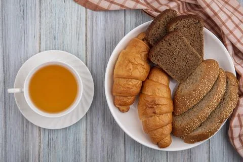 Top view of breads as croissant sliced rye and seeded brown cob in plate on.. Stock Photos