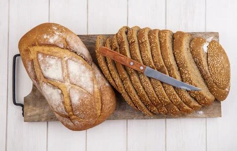 Top view of breads as sliced brown seeded cob and crusty bread with knife o.. Foto stock