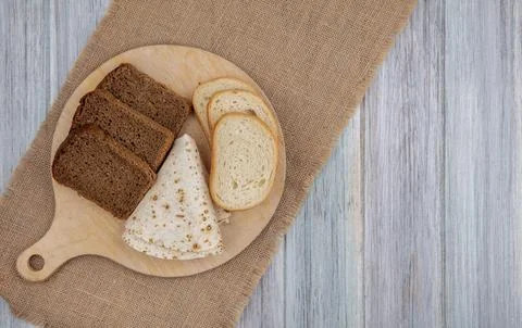 Top view of breads as sliced rye white ones and flatbread on cutting board .. Stock Photos
