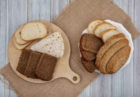 Top view of breads as sliced rye white seeded brown cob ones and flatbread .. Stock Photos