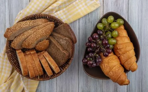 Top view of breads as sliced seeded brown cob rye and crusty ones in basket.. Stock Photos