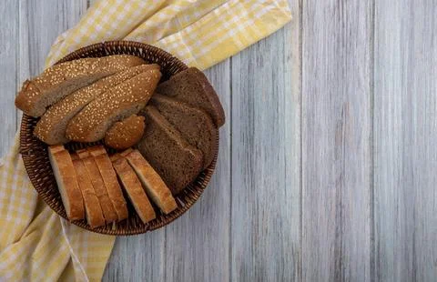 Top view of breads as sliced seeded brown cob rye and crusty ones in basket.. Stock Photos