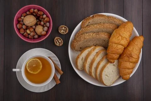 Top view of breads as sliced seeded brown cob baguette and croissants in pl.. Stock Photos