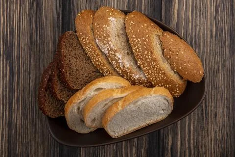 Top view of breads as sliced seeded brown cob rye and white ones in bowl on.. Stock Photos