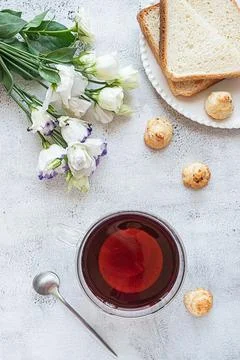 Top view of a breakfast with a cup of tea, cookies, bread and flowers Stock Photos