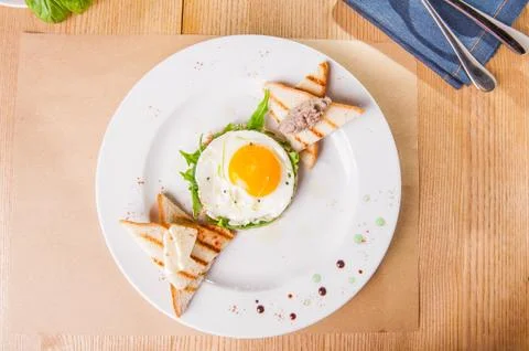 Top view Breakfast with fried eggs, toasts and meat pate on white plate on th Stock Photos