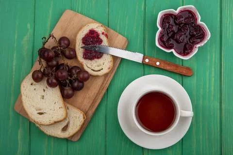 Top view of breakfast set with bread slices and grape with knife and cup of.. Stock Photos