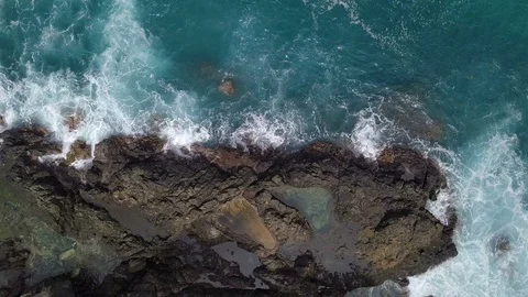 Top view of breaking waves on rock with big footprint Stock Footage 113046796