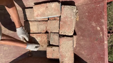 Top view of bricks being placed on red wheelbarrow Stock Footage 316539226