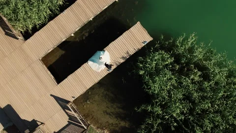 Top view a bride and groom walking hand in hand on the pier. Sea, lake, pier Stock Footage 236763154