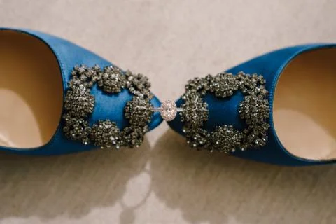 Top view of the bride's engagement ring with a gem between blue shoes with a Stock Photos