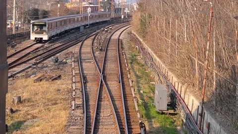Top view from bridge on rails, arrival and departure of metro train Stock Footage 323651768