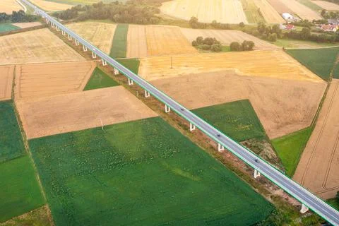 Top view of bridge road over green fields Stock Photos