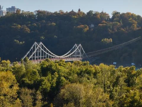 A top view of the bridge, which is behind the trees of the park Stock Photos