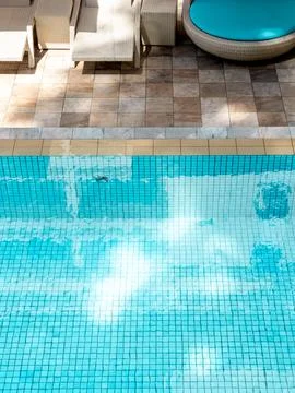 Top view of bright, clean and clear water pool on blue grid mosaic tiles in.. Stock Photos